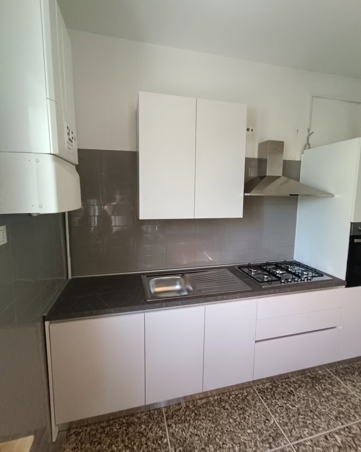 Cucina bianca ad angolo con colonna forno