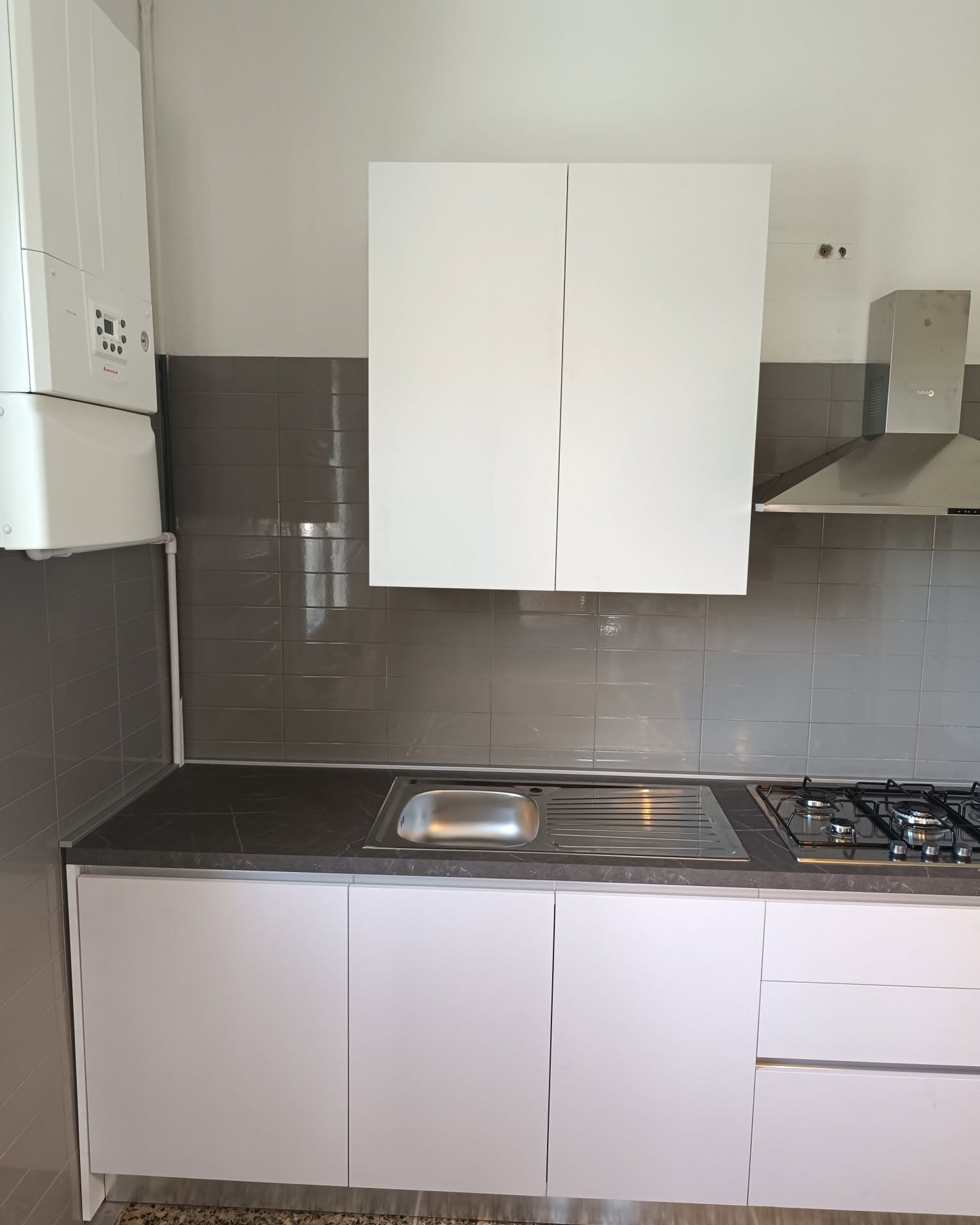 Cucina bianca ad angolo con colonna forno